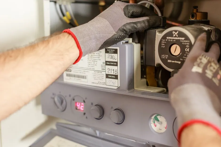 Technician running a professional drain cleaning cable machine inside a Cedar Park, Texas home.